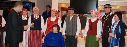 Degučių folkloro kolektyvo vadovė A.Baltutienė (kairėje) sveikino kretingišę L. Kačėnienę.