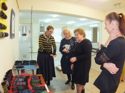 Į parodos atidarymą susirinkusios moterys pačios bandė megzti riešines. E.Lukošiaus nuotr.